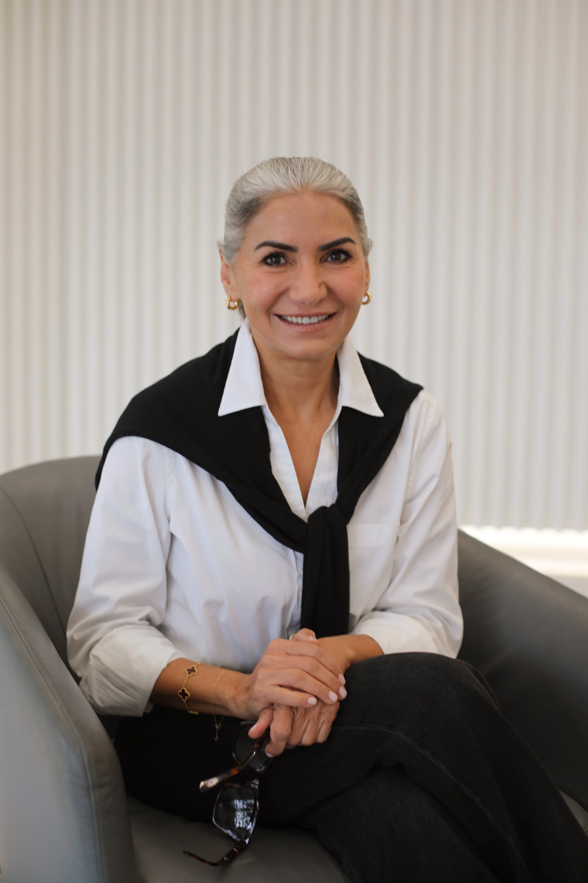 Kathy Sarai, AMFT, seated in a white blouse and black vest